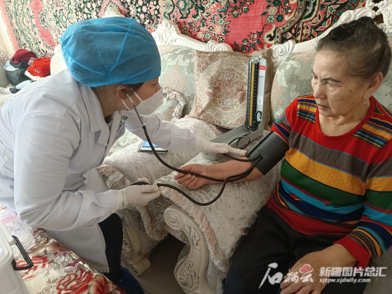 1月29日，塔城市和平街道社区卫生服务中心家庭医生服务团队的医护人员来到新华社区居民丽达家中，给患有高血压的丽达做慢病随访服务。马瑞芳摄